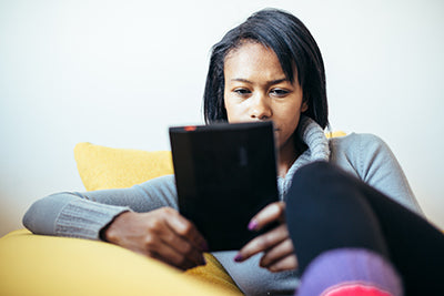 Black woman reading ebook on her tablet