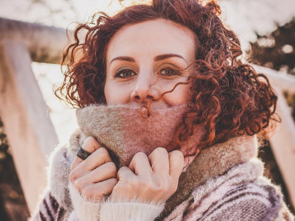woman with curly red hair wearing a sweater