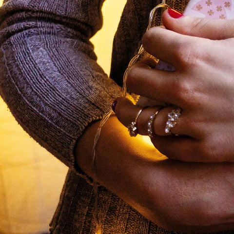 hand with stacked fashion rings on one finger