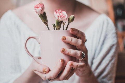 woman holding a mug with flowers inside