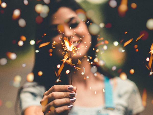 smiling woman holding sparkles