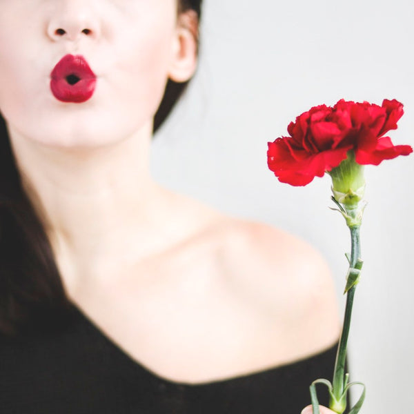 woman with red lipstick and red flower