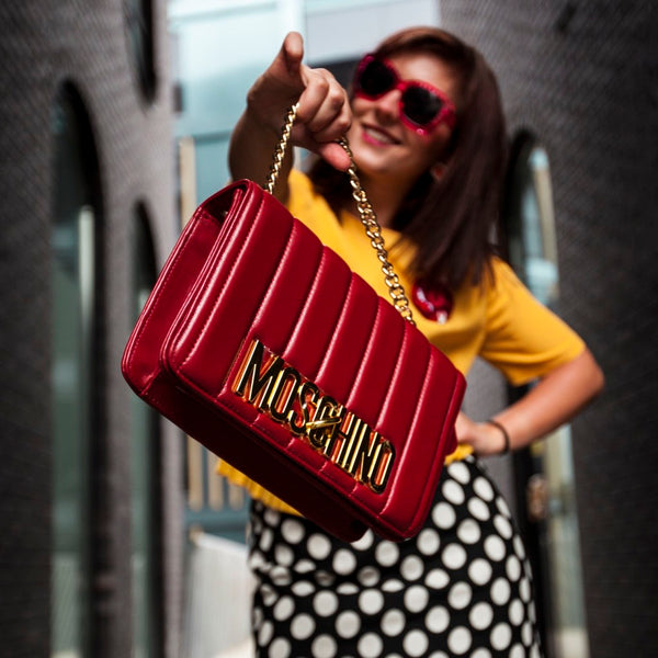 woman showing off her red shoulder bag