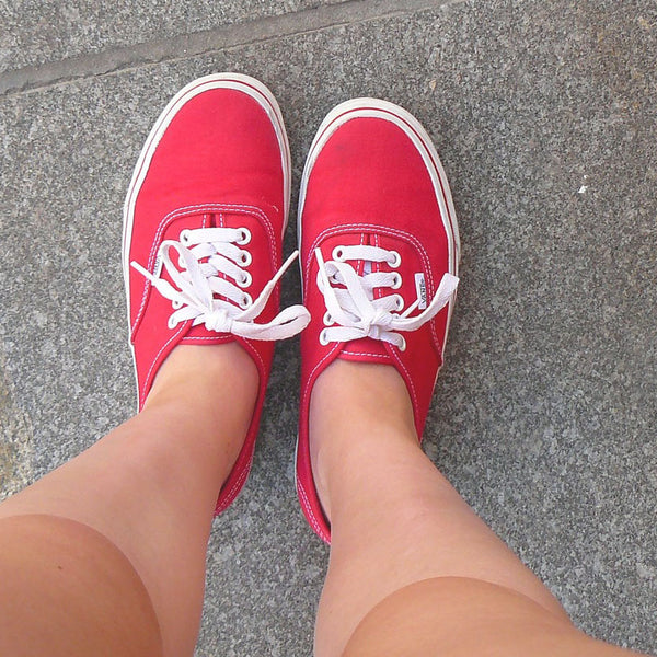 picture of legs and shoes wearing red sneakers