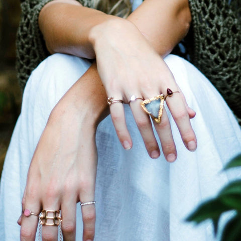 woman's hands wearing layered fashion rings