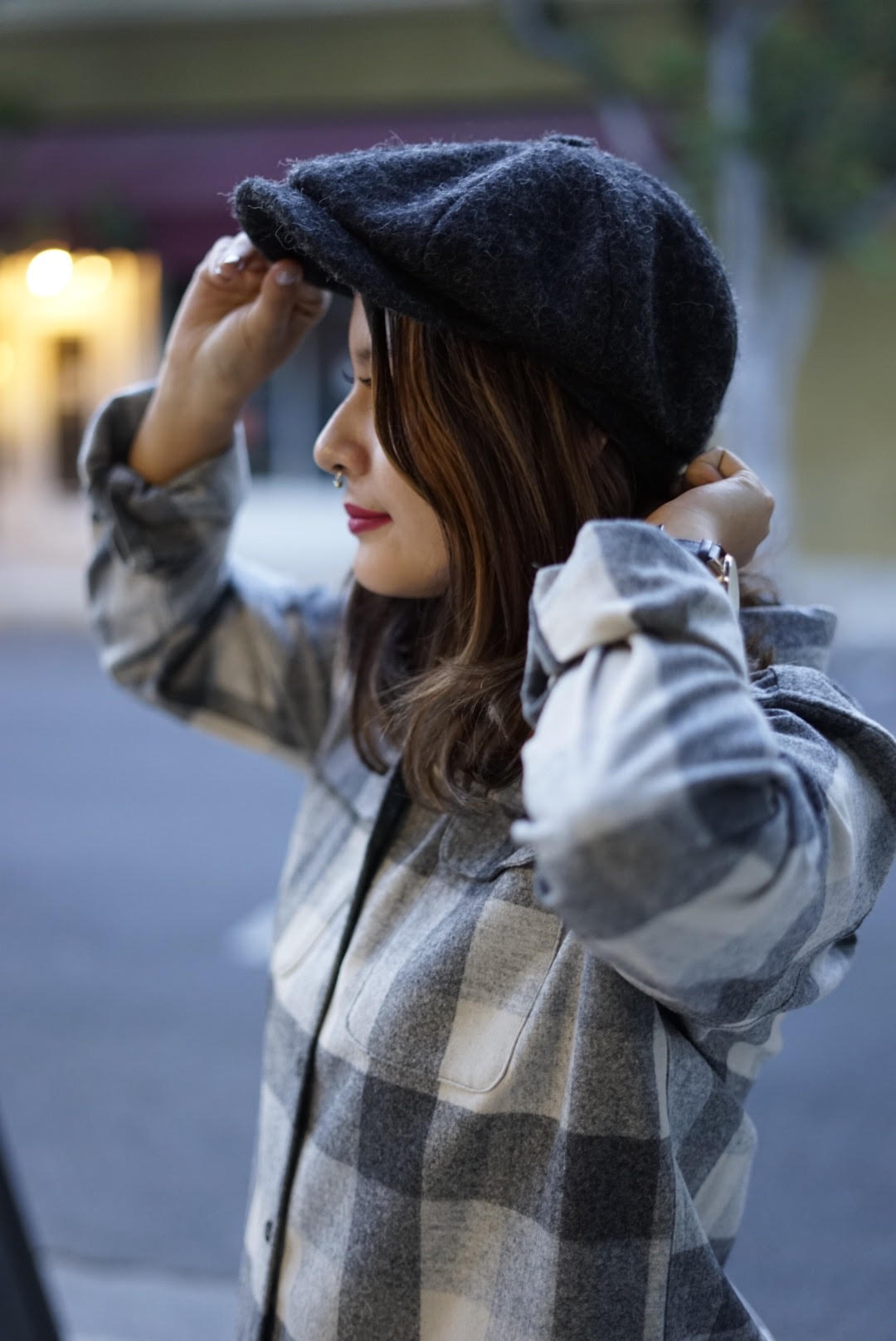 womans pendleton board shirt also wearing an adjusting hat beanie