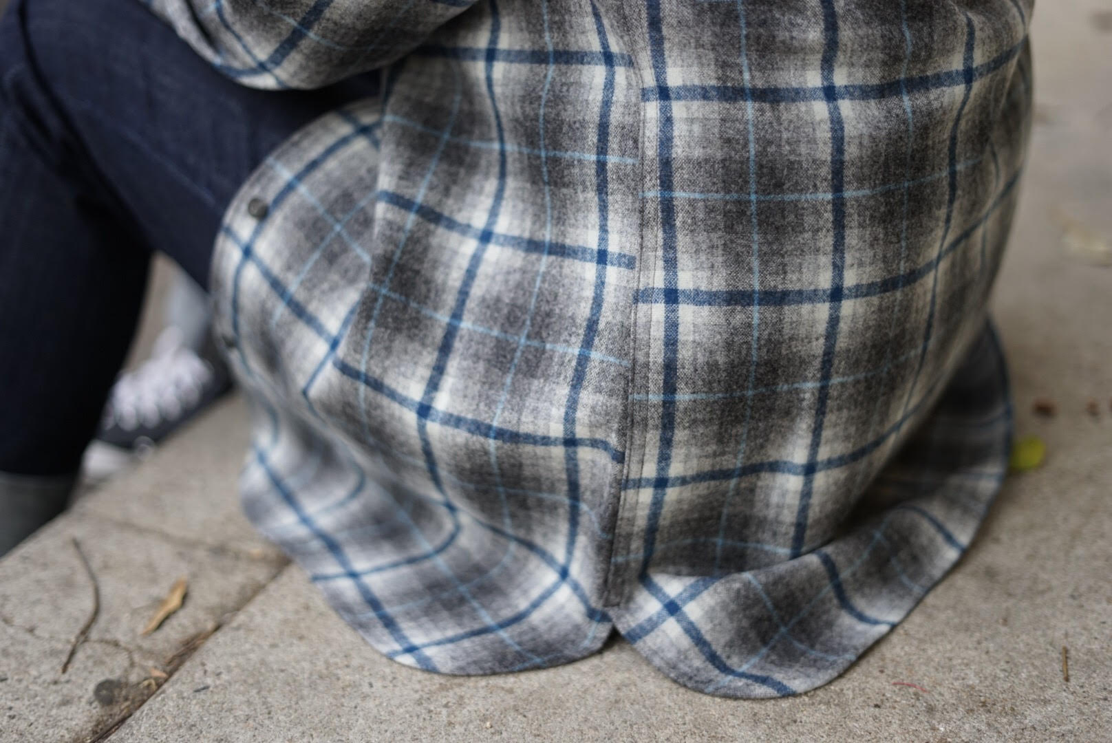 womans pendleton board shirt sitting on the concrete stoop