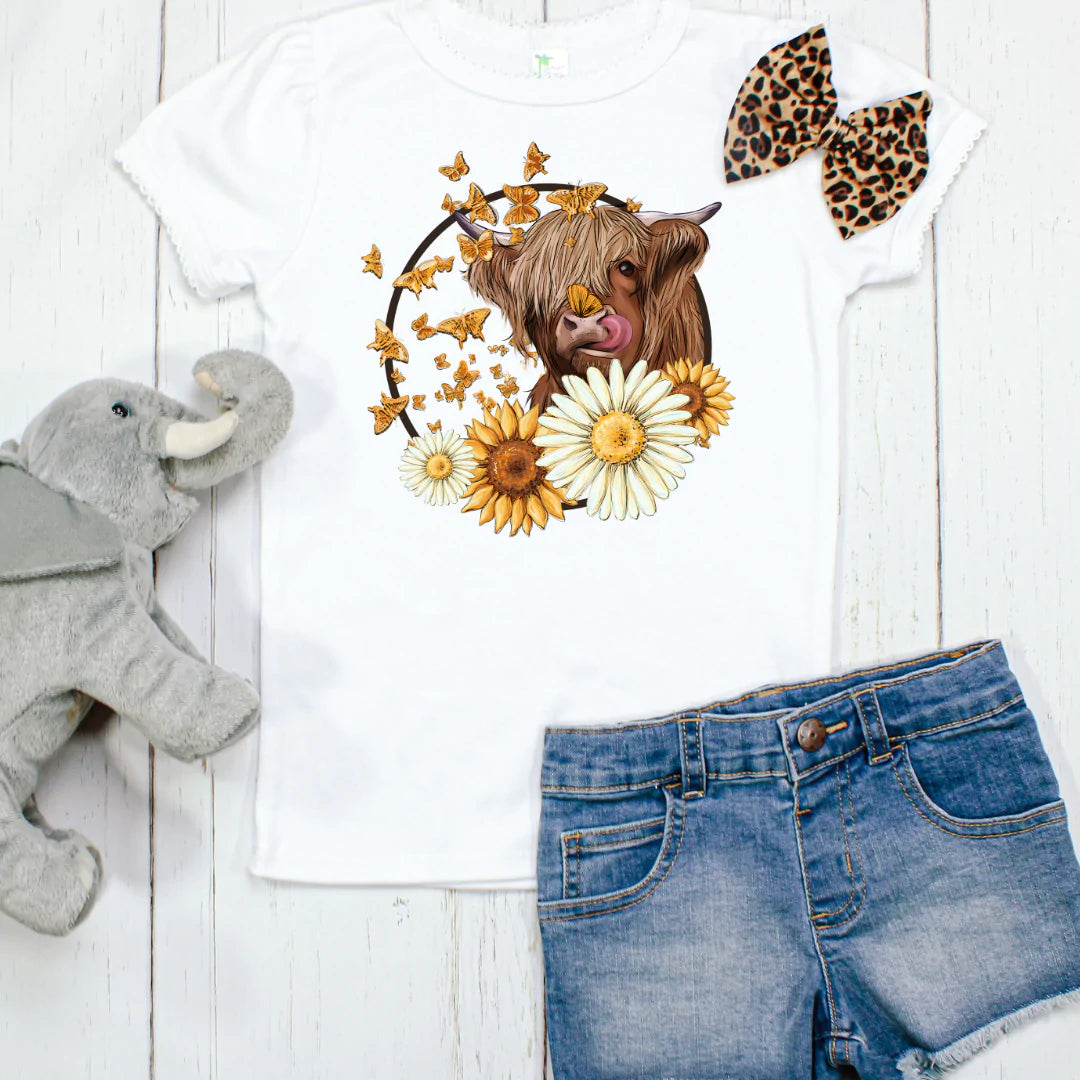 ANIMALS: HIGHLAND COW AND DASIES