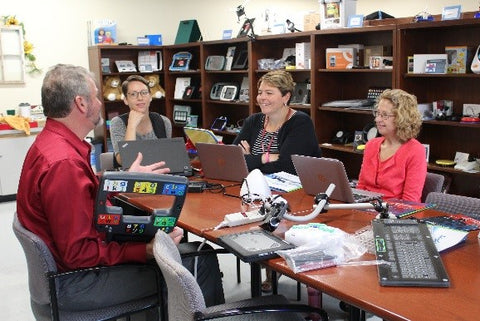 Members of the EASTCONN Assistive Technology team listen as Glen shares one of the LoganTech AAC devices; the Megabee®