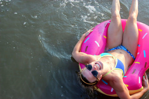 woman wearing a JOLYN bikini in a donut pool float