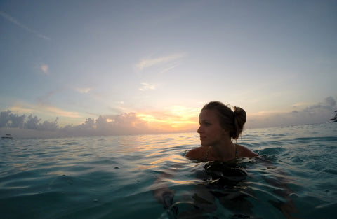 woman in the ocean at sunset