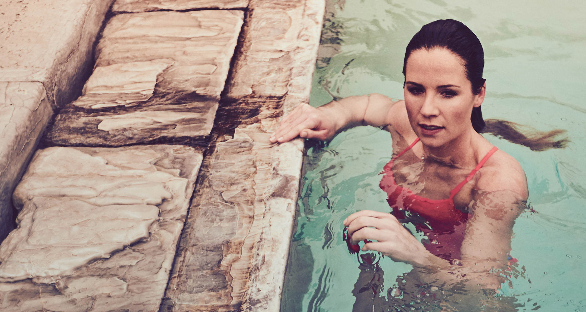 a woman in a one piece JOLYN bathing suit, in pool