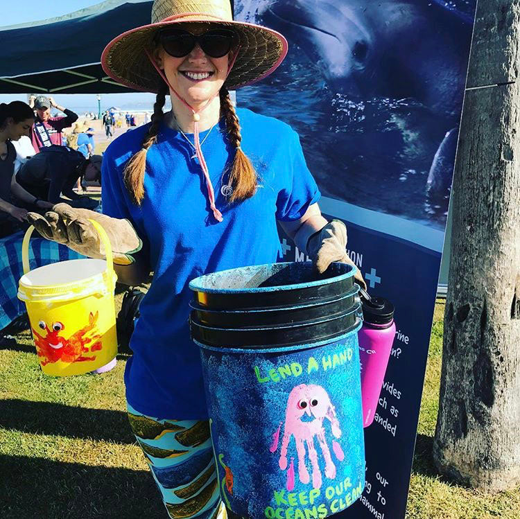 woman holding buckets for beach cleanup