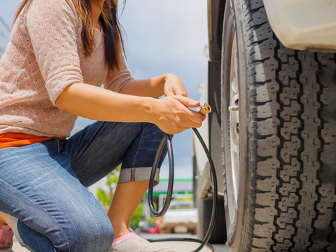 woman checking tire pressure
