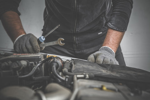 man working on car engine