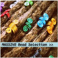 An assortment of different coloured spiral dreadlock hair beads displayed fitted onto dreadlocks