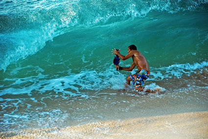 Clark Little shooting in shorebreak standing on sand