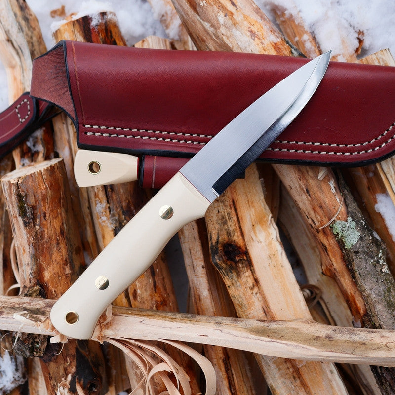 Adventure Sworn Classic bushcraft knife with a scandi grind and ivory paper micarta handle scales