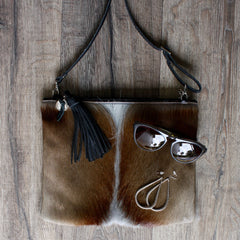 flatlay of mooi hide bag, elk sunglasses, stella+gemma jewellery