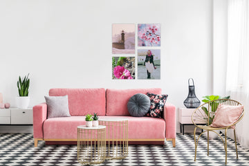 A chic apartment lounge featuring a bright pink sofa in front of a gallery wall grid of a matching display plates/metal poster prints  