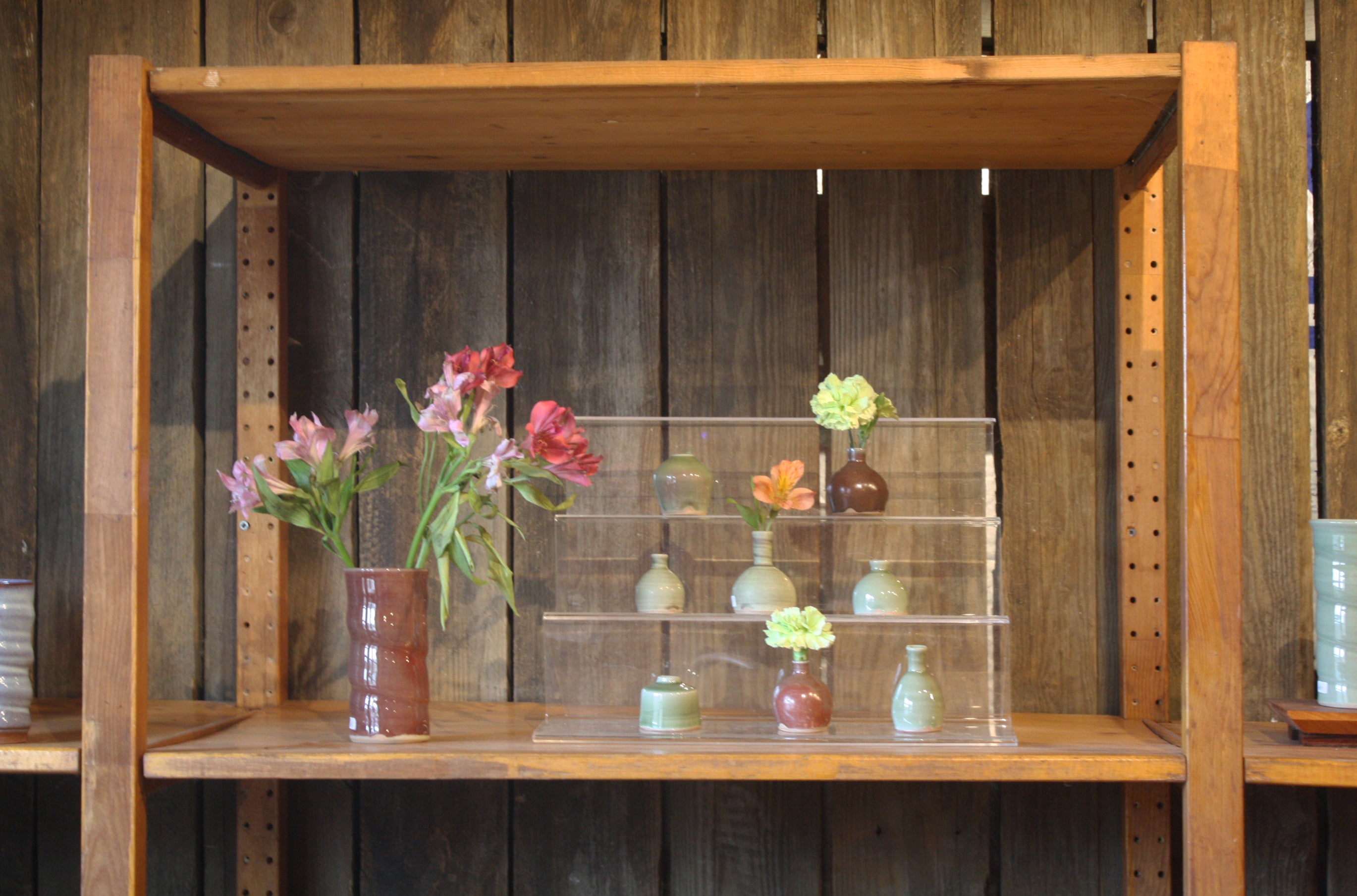 Fresh flowers sit inside of small vases at Greenbridge Pottery Studio
