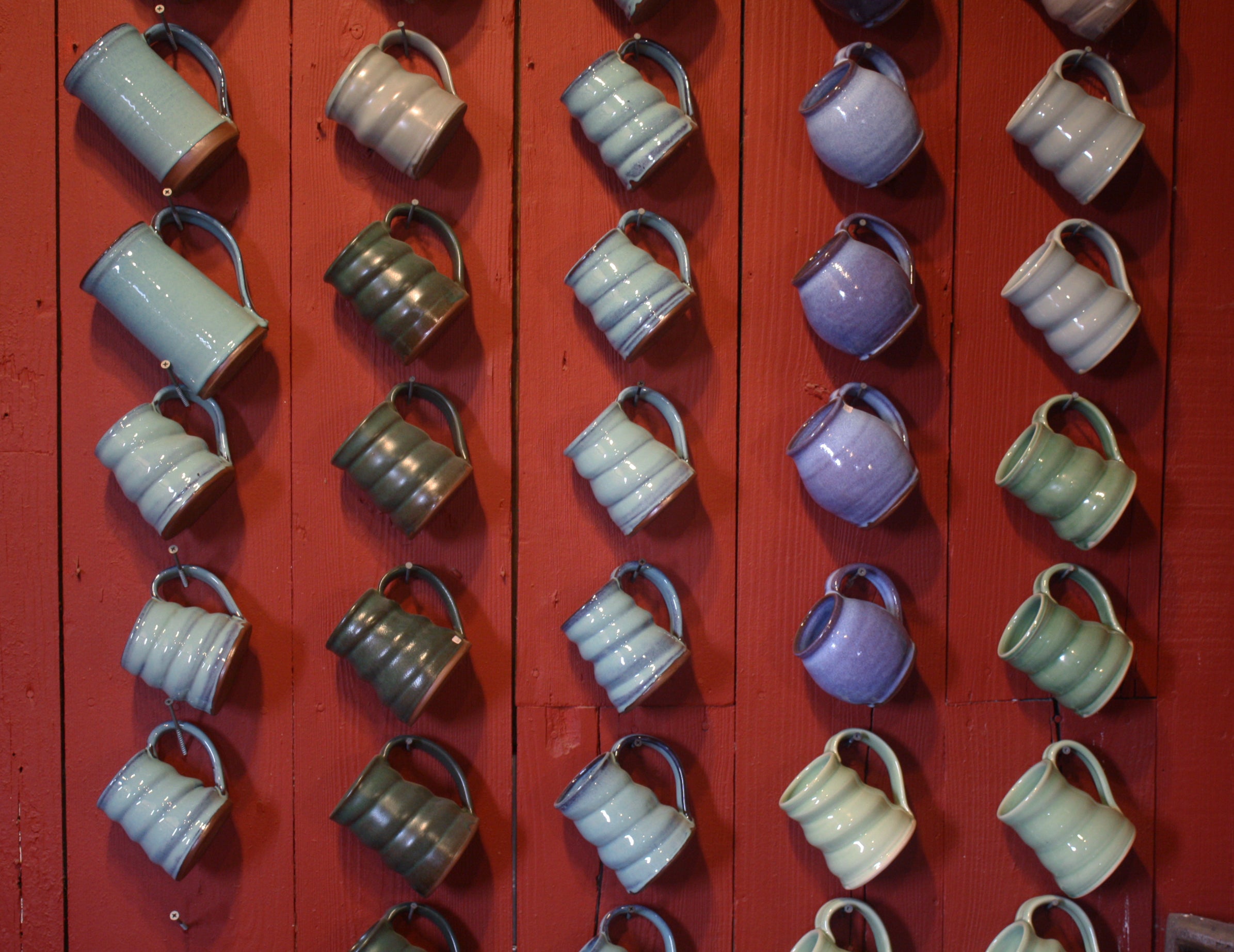 Mugs hanging on the wall at Greenbridge Pottery Studio