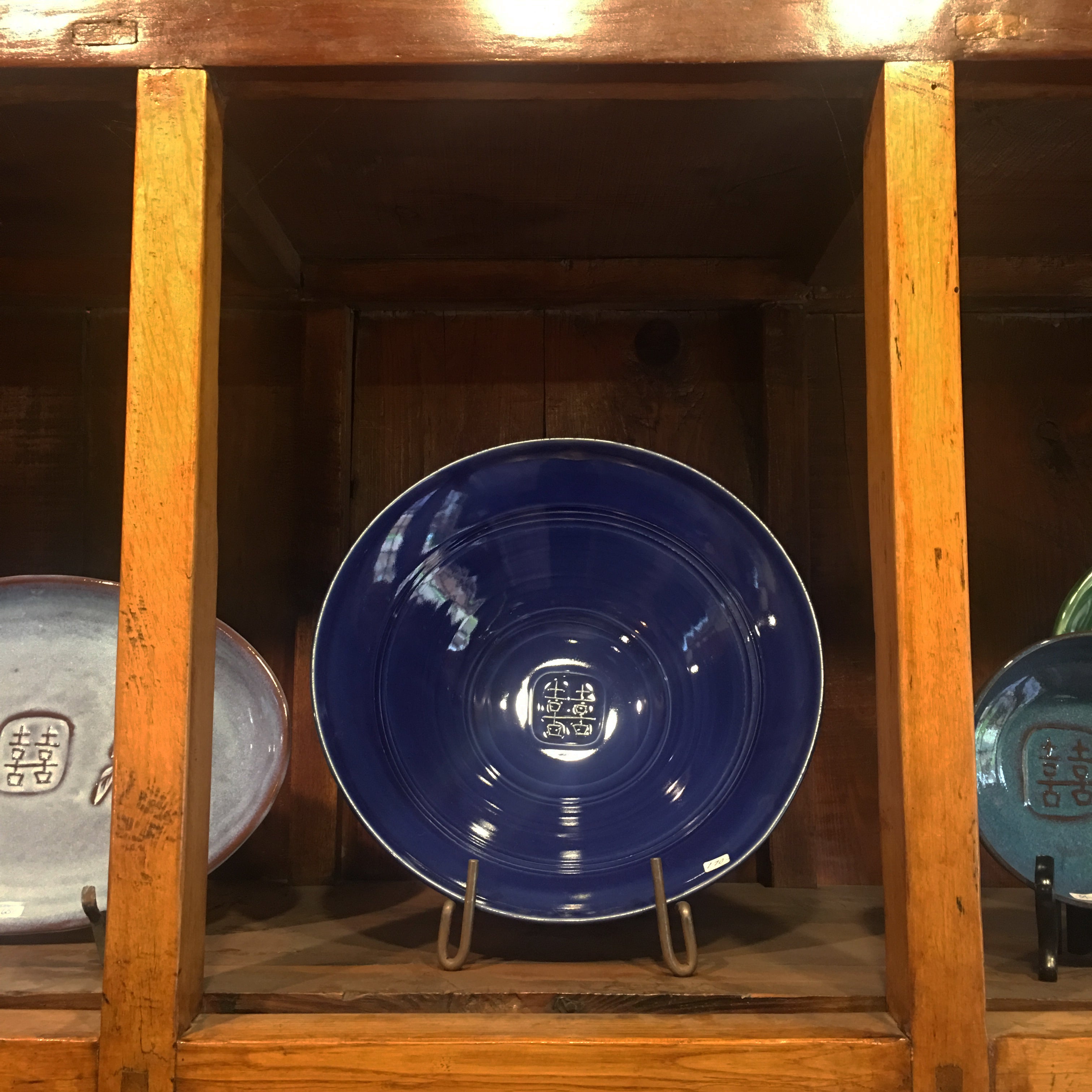 Deep blue bowl displayed at Greenbridge Pottery Studio