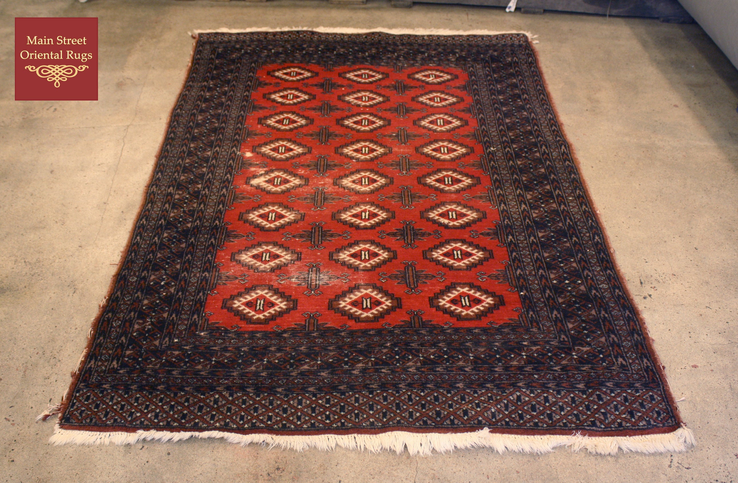 Vintage rug repair, before photo of Pakistani Bokhara rug