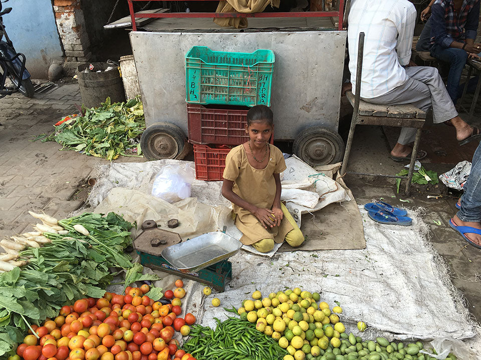 A young India girl selling citrus fruits and vegetable with her brother - Main Street Oriental Rugs