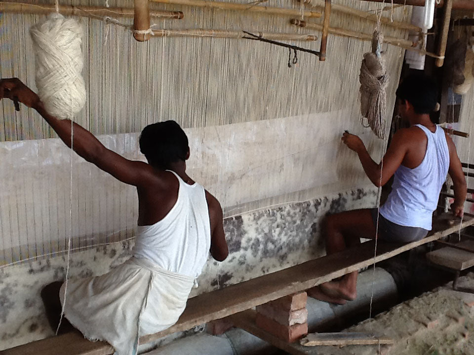 Two weavers creating a rug at their loom - Main Street Oriental Rugs