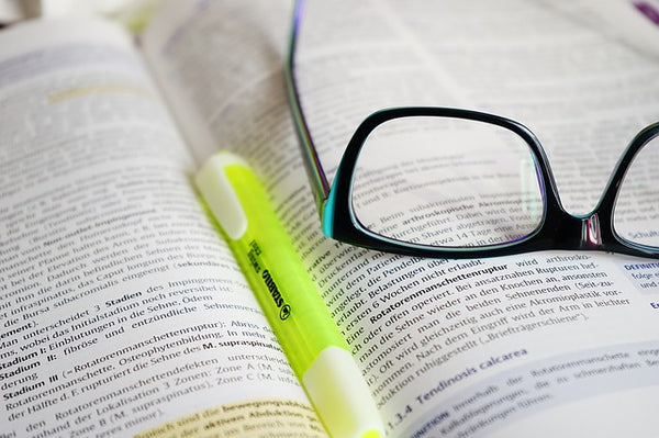 Image of reading glasses lying on an open book
