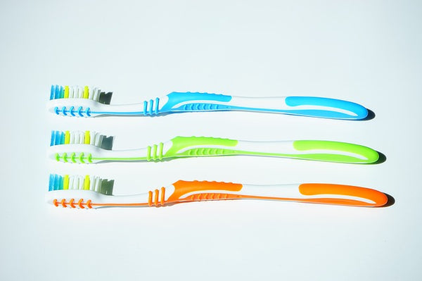 Three toothbrushes on a bench 