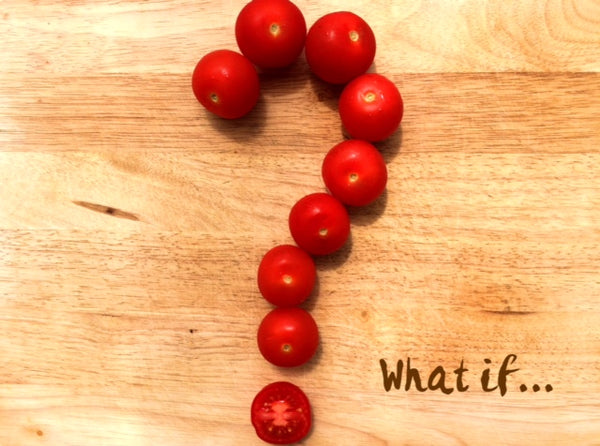 Question mark made out of cherry tomatoes on a wooden board, with the question "What if..."