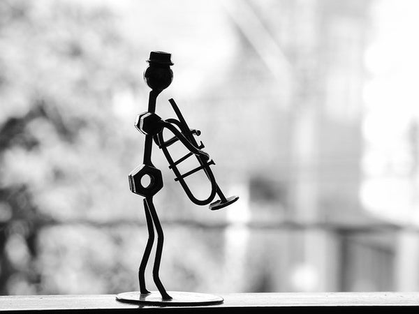 Silhouette of a figure holding a trumpet