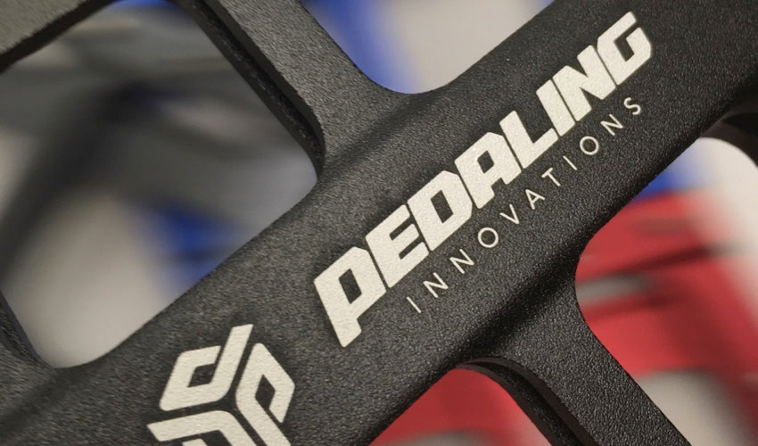 Close-up view of a Black Catalyst Pedal and the Pedaling Innovations logo