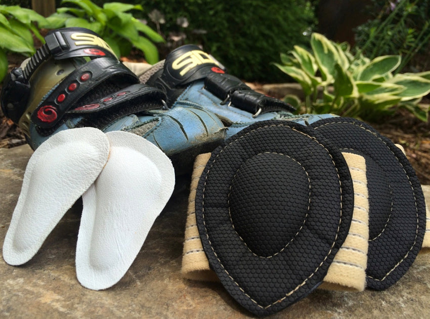 A pair of Pedag metatarsal pads and Strutz foot pads propped up in front of a pair of conventional road cycling shoes