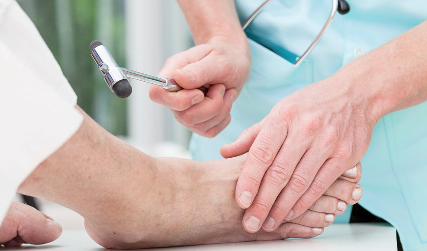 Foot surgeon performing a reflex test on a patient