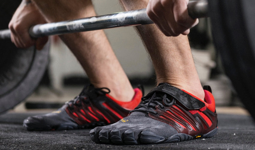 A powerlifter, wearing Vibram FiveFingers shoes, preparing for a lift