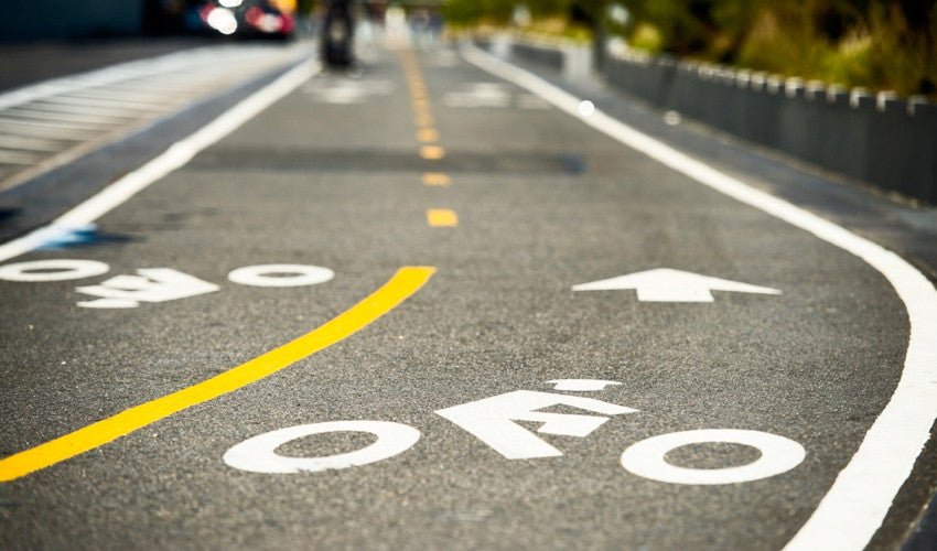 Urban bike path with bike logos, directional arrow, and other lane markings painted on the asphalt