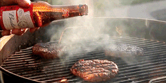 pouring beer over burgers on a hot charcoal grill