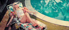 lady tanning in chair by pool with arm floats on 