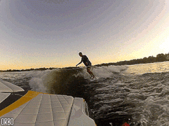 male rider wakesurfing behind yellow boat