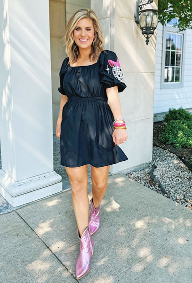 Down To Disco Dress, Black dress featuring an elastic waist, It is adorned with a white sequin disco ball and a pink cowgirl hat on both sleeves.