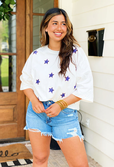 Like a star sequin top. White tee with blue sequin stars outlined in gold.
