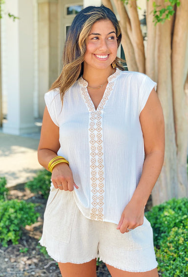 Set On You Top, White sleeveless top is made of gauze fabric and features intricate tan embroidery detail running down the front