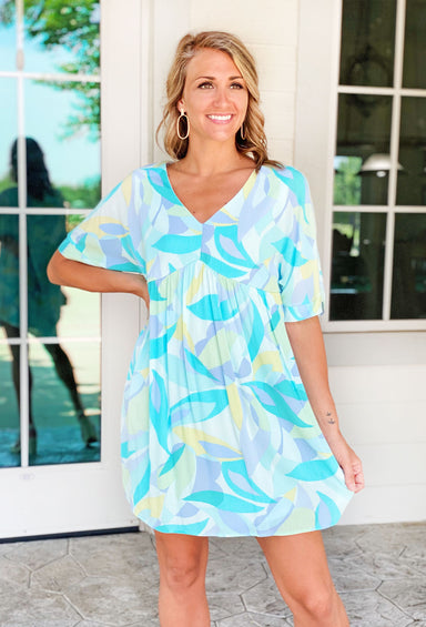 Stay In Paradise Dress, Blue and green abstract print mini dress with short sleeves and a v neckline