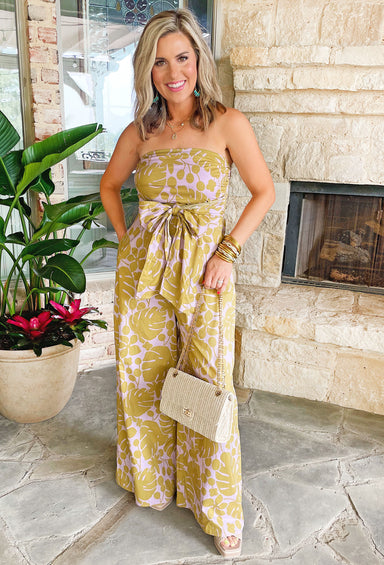 Weekend In Napa Jumpsuit, strapless lavender wide leg jumpsuit designed with a luxurious olive palm leaf print and includes a smocked backing and front tie detail