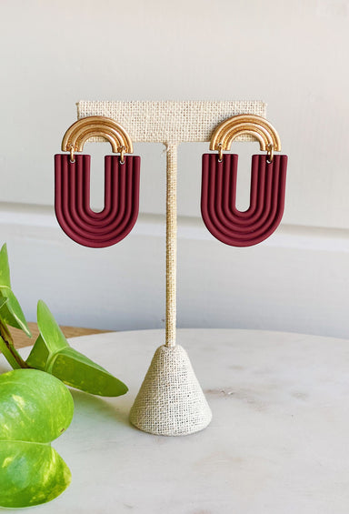 Clay U-Shape Drop Earrings, U-shape arches hang from a gold post, both with geometric detail