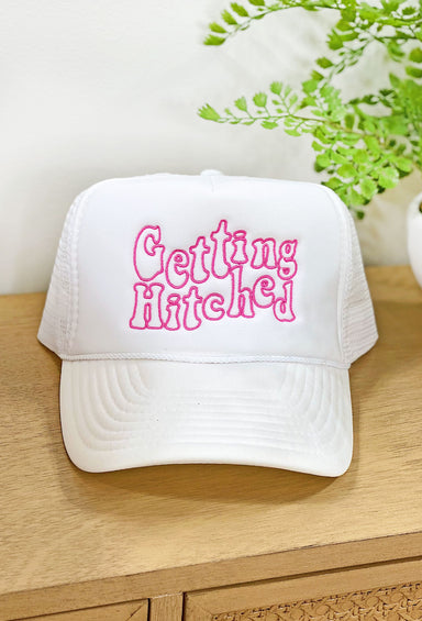 Friday + Saturday: Getting Hitched Trucker Hat, white trucker hat with "getting hitched" embroidered in pink on front