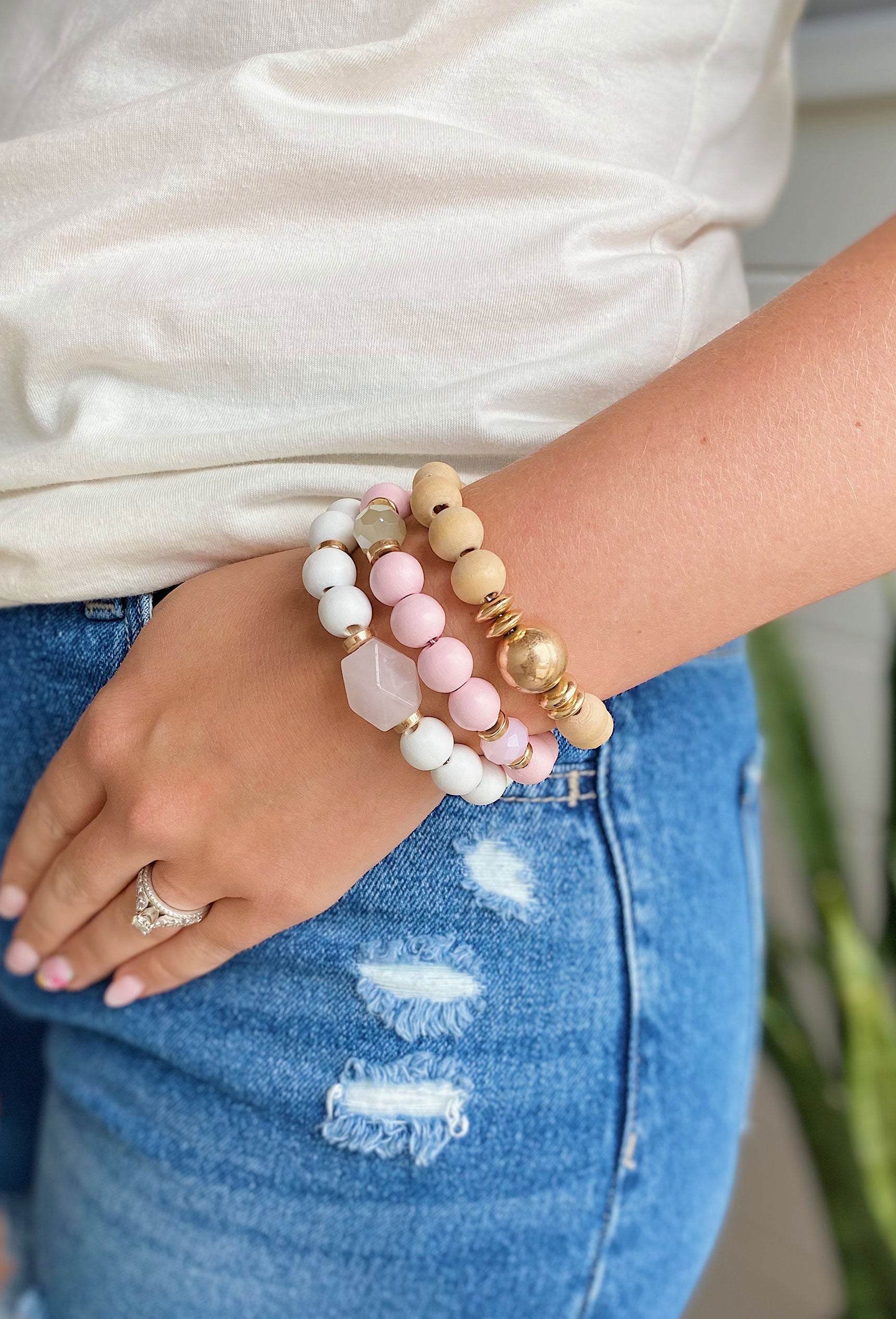 Good Days Ahead Bracelet Set, A set of white, pink, and tan wooden beaded bracelets with gold accent beads featuring an iridescent stone detail